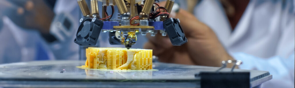 Interested,Multiethnic,Scientists,Gathering,Around,3-d,Printer,And,Watching,Process